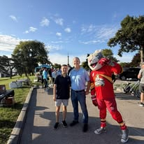 Alan Lewandowski with a young supporter and a costumed mascot along the Port Huron waterfront